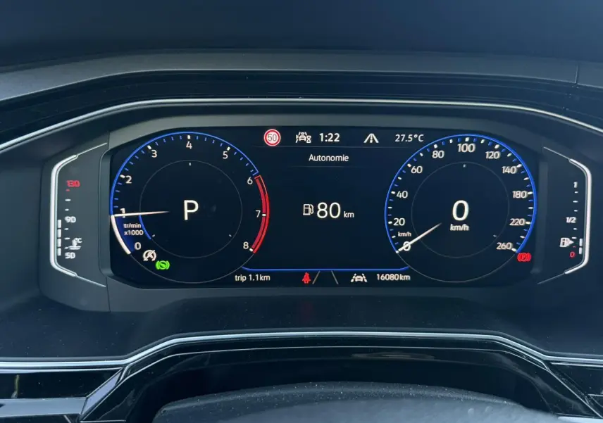 Vue rapprochée du tableau de bord numérique du Volkswagen Taigo gris, affichant la vitesse à 0 km/h et l'autonomie à 80 km.