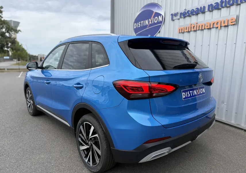 Vue 3/4 arrière droite du SUV MG ZS 2025 en bleu Como Metal, avec feux arrière LED et jantes alliage bicolores.