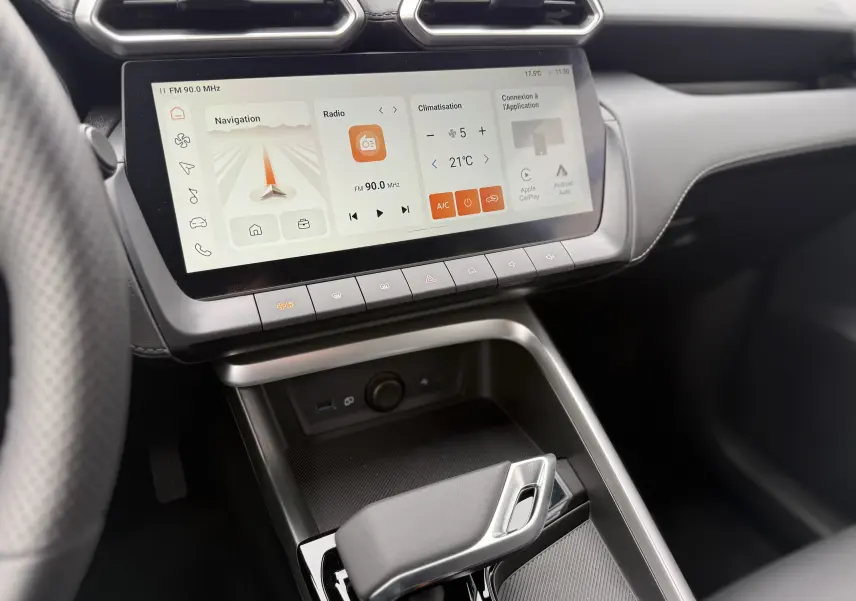 Vue intérieure rapprochée du tableau de bord et de la console centrale du MG MOTOR ZS 1.5L HYBRID+ 2025 avec écran tactile et levier de vitesse moderne.