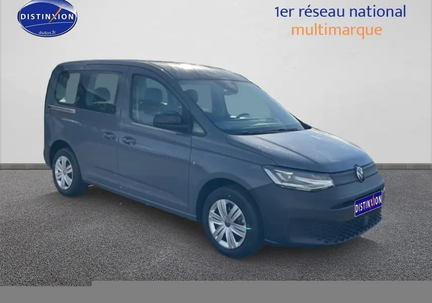 Volkswagen Caddy gris pur vue 3/4 avant droit sur fond neutre avec logo Distinxion visible.