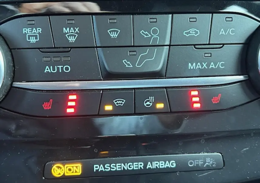 Gros plan sur la console centrale du Ford Puma noir Agate, affichant les commandes de climatisation et sièges chauffants.