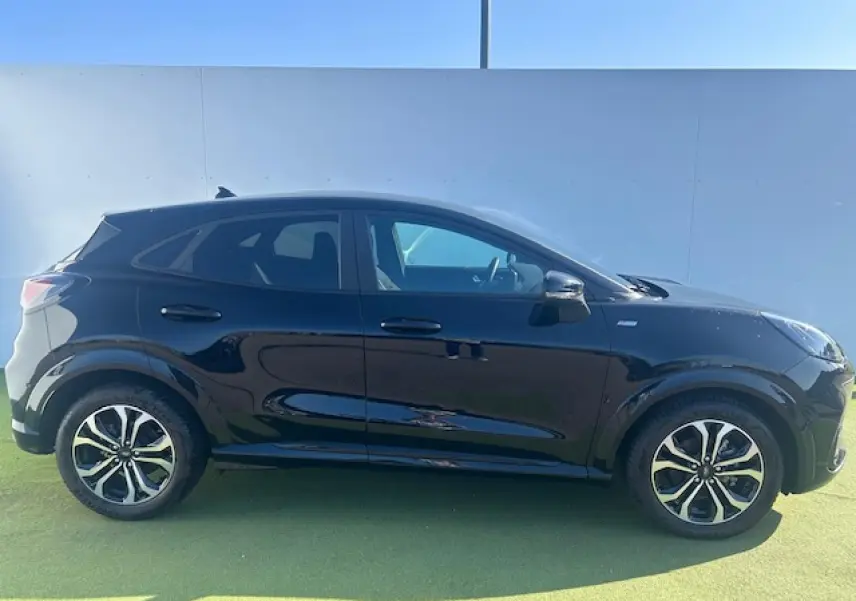 Profil côté gauche d'un Ford Puma noir Agate 2023 avec jantes alliage et badges ST-Line visibles.