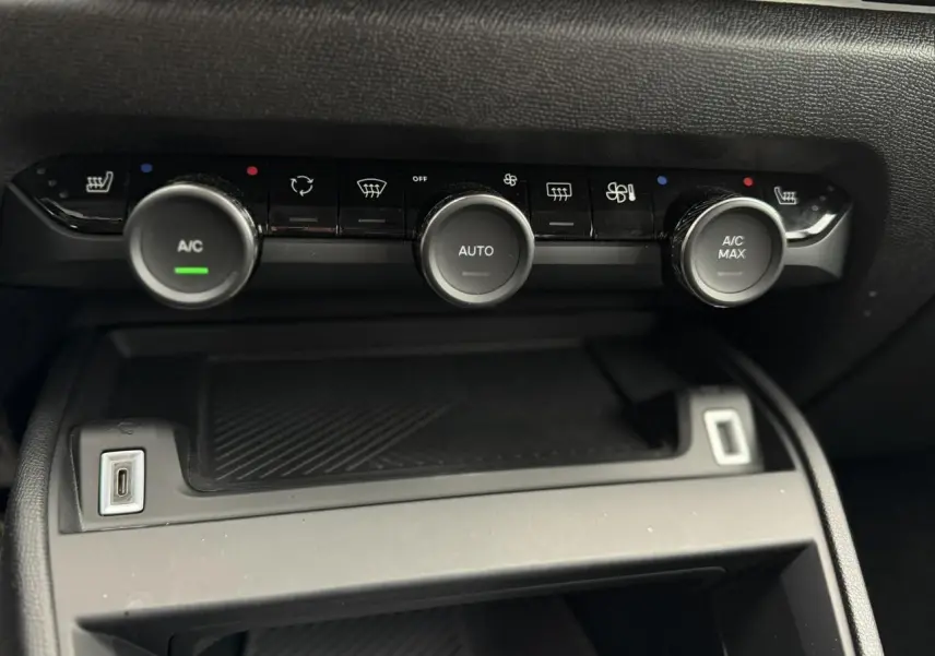 Détail de la console centrale noire avec commandes de climatisation automatique et ports USB du Citroën C4 2024.
