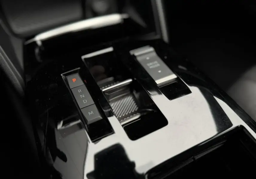 Gros plan sur la console centrale noire brillante de la Citroën C4 2024, avec sélecteur de boîte automatique et bouton start/stop.