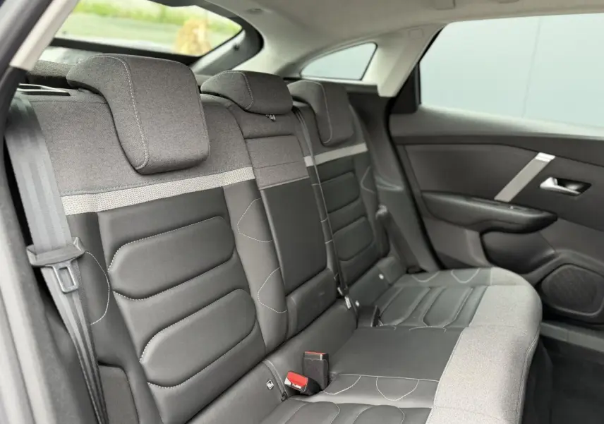 Vue latérale droite de la banquette arrière gris et noir avec appuie-têtes et ceintures visibles du Citroën C4 2024.