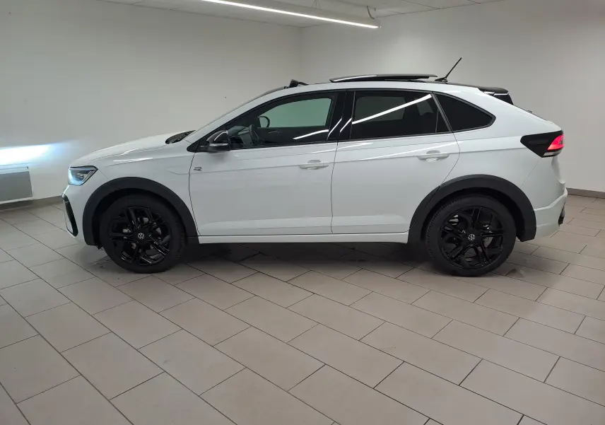 Vue de profil côté gauche d'un Volkswagen Taigo blanc pur avec toit noir et jantes noires en alliage.
