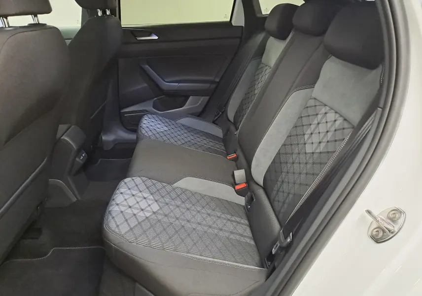Vue intérieure côté droit de la banquette arrière du Volkswagen Taigo 2025 avec sièges tissu gris à motifs géométriques.