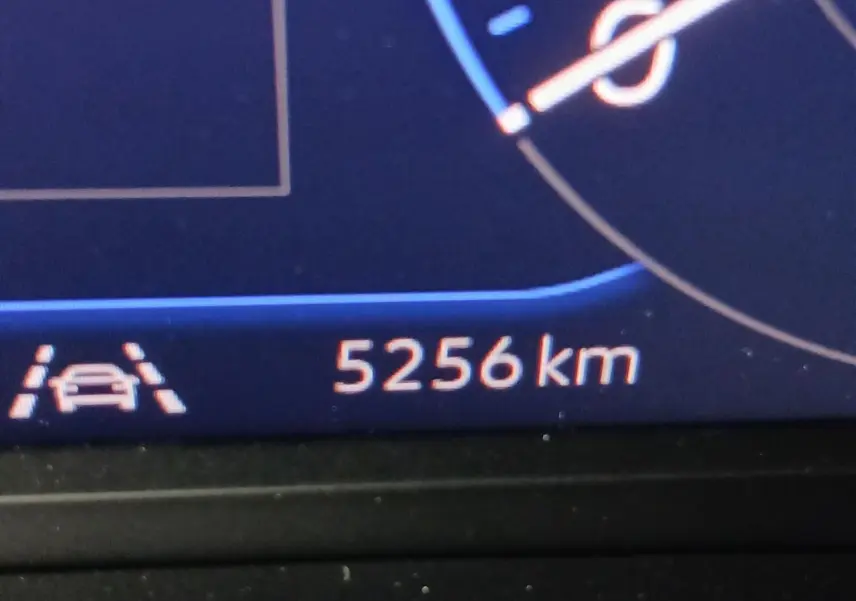 Vue rapprochée du tableau de bord numérique affichant 5256 km et l'icône d'assistance au maintien de voie.