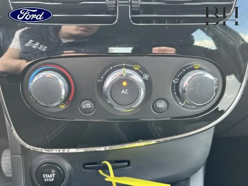 Panneau de commande de climatisation avec réglages manuels sur tableau de bord noir brillant d'une Renault Clio gris Cassiopée.