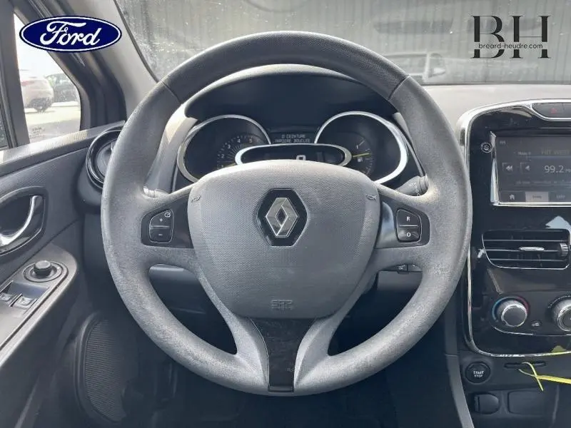 Vue intérieure centrée sur le volant cuir gris de la Renault Clio 2013 avec tableau de bord et écran tactile visibles.