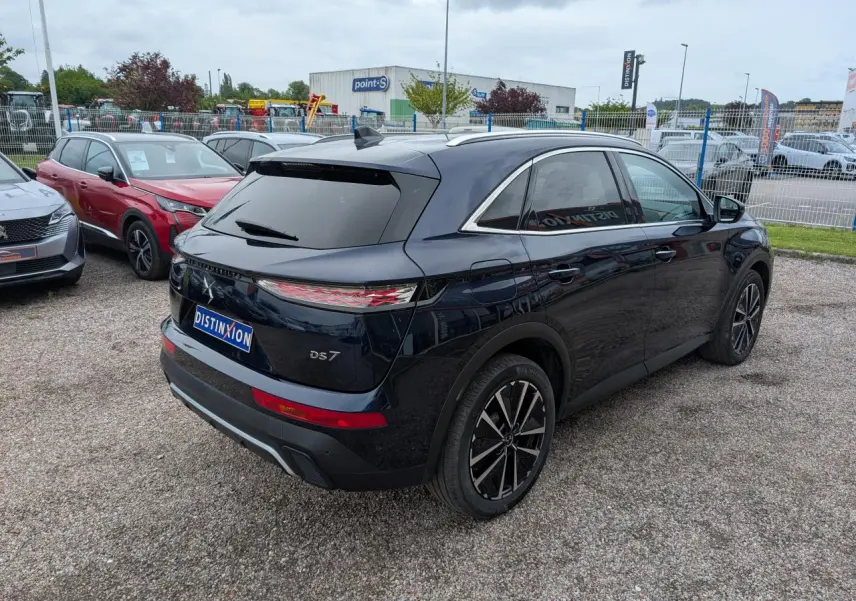 Vue 3/4 arrière droite d'un DS7 bleu métallisé avec feux arrière LED 3D et jantes alliage noires.