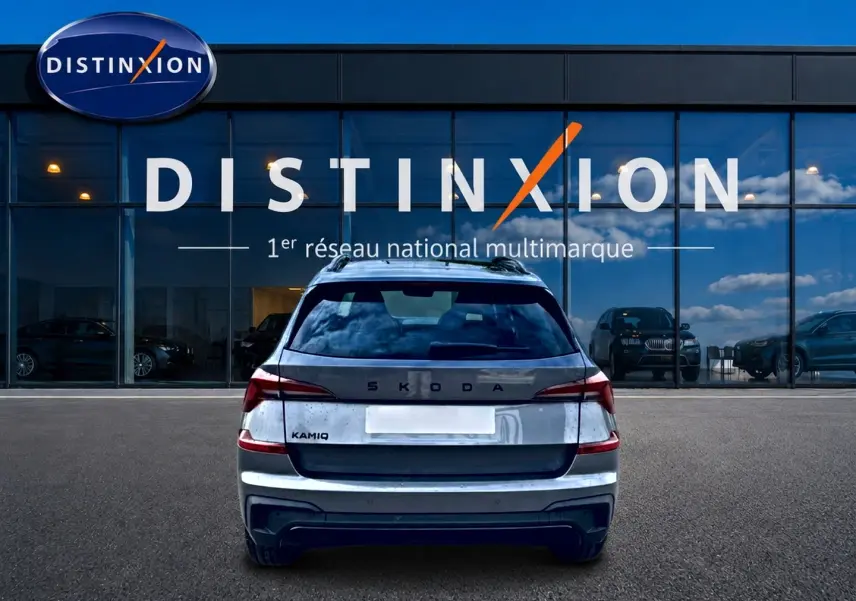 Vue arrière d'un Skoda Kamiq gris graphite 2026, avec feux LED et logo distinctif sur fond de vitrine Distinxion.