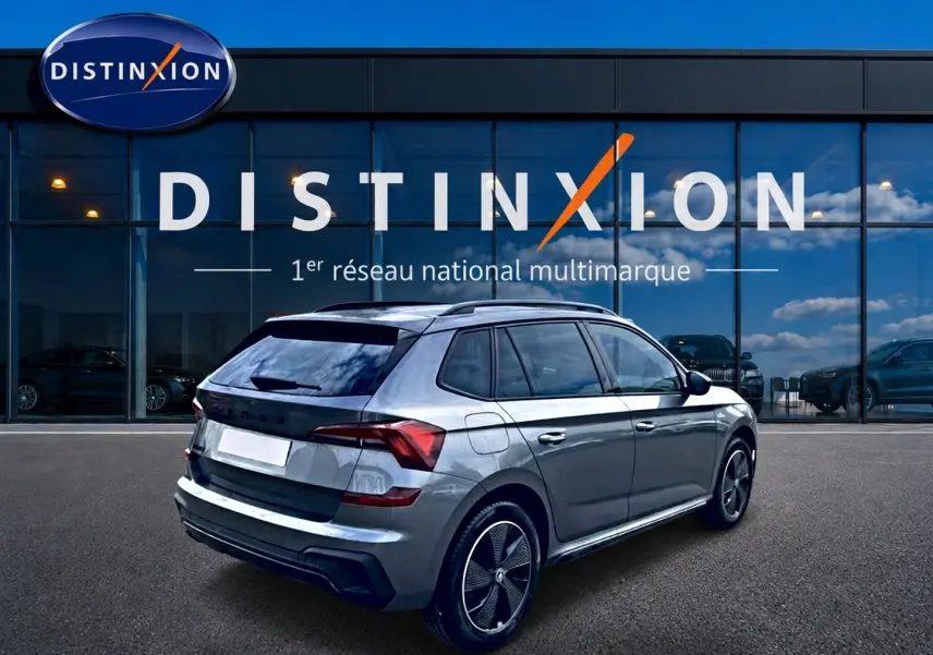 Vue 3/4 arrière droite du Skoda Kamiq gris graphite 2026 avec jantes alu et toit panoramique en verre.