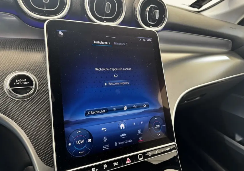 Vue intérieure du tableau de bord du Mercedes GLC 300 E Business Line 2023 avec écran tactile central et boutons de commande.