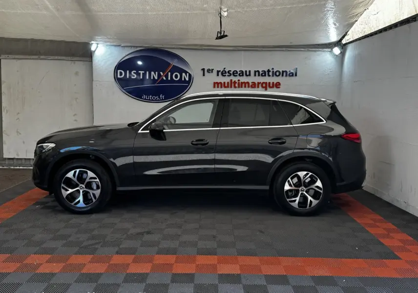 Vue de profil côté gauche d'un Mercedes GLC 300 E Business Line 4MATIC gris foncé dans un showroom.