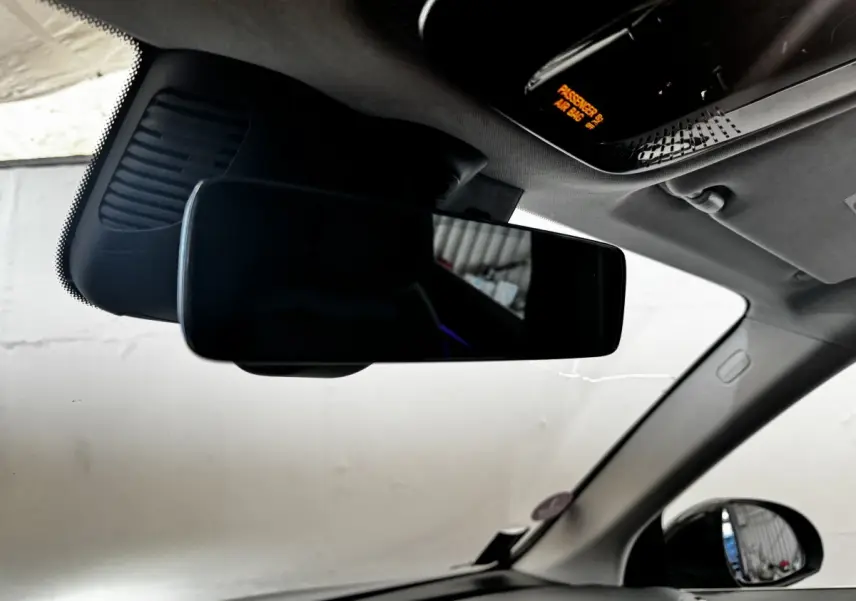 Vue intérieure du rétroviseur central d’un Mercedes GLC 300 E Business Line 2023, gris foncé.