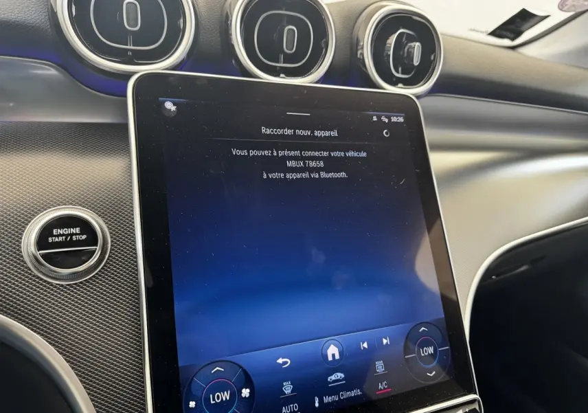 Vue rapprochée de l’écran tactile central et du bouton start/stop dans l’habitacle noir du Mercedes GLC 300 E Business Line.