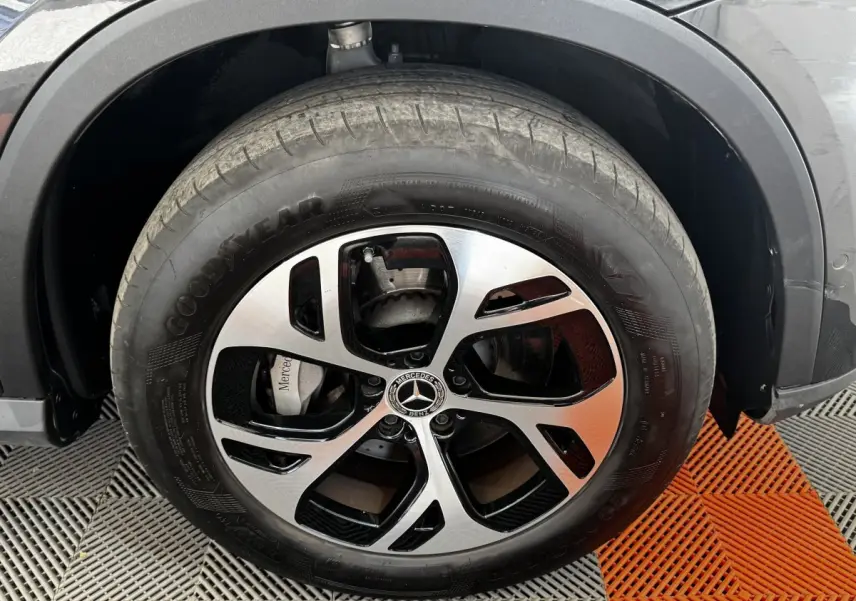 Gros plan sur la roue avant droite du Mercedes GLC 300 E Business Line gris foncé avec jante alliage bicolore.