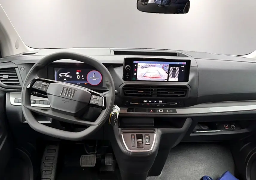 Vue intérieure avant du Fiat Scudo Combi 2026, tableau de bord gris avec écran tactile et volant multifonctions.