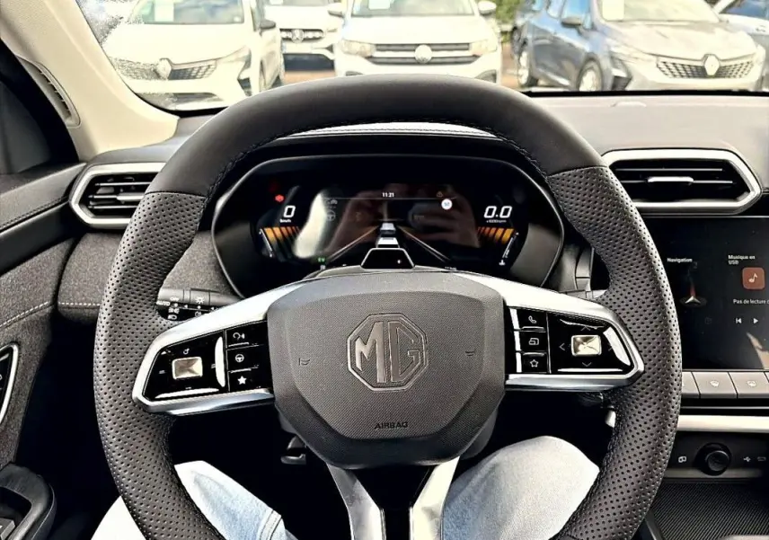 Vue intérieure côté conducteur du tableau de bord et console centrale du MG MOTOR ZS Hybrid 197 gris foncé, avec écran tactile et levier de vitesse.