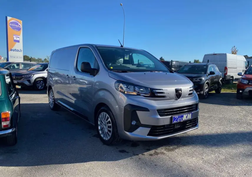 Vue 3/4 avant droite d'un Peugeot Expert Fourgon gris Artense garé en extérieur, avec calandre et phares modernes visibles.