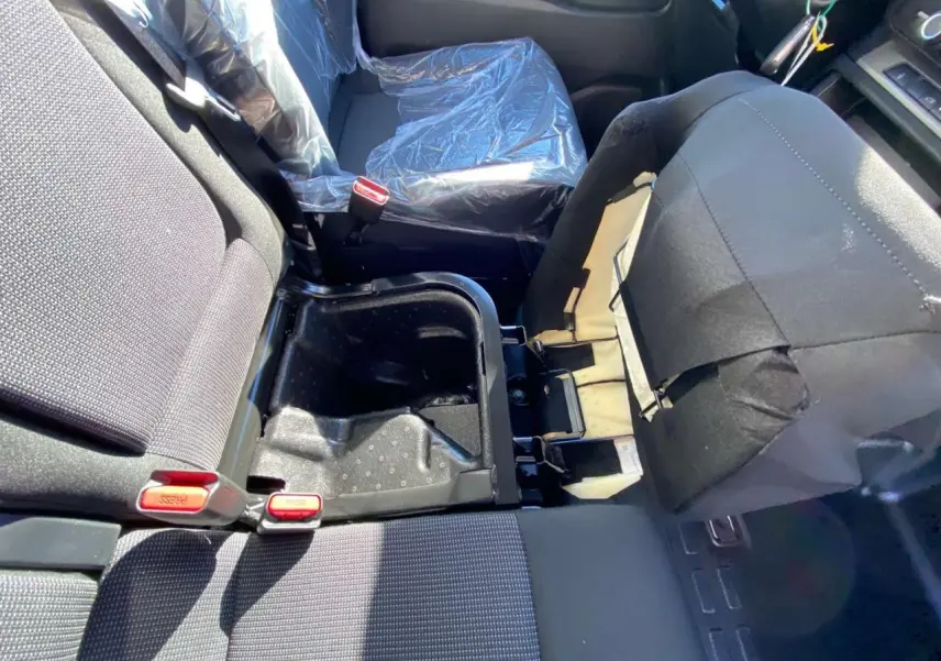 Vue intérieure du siège passager droit relevé du Peugeot Expert Fourgon gris, montrant le rangement sous assise ouvert.