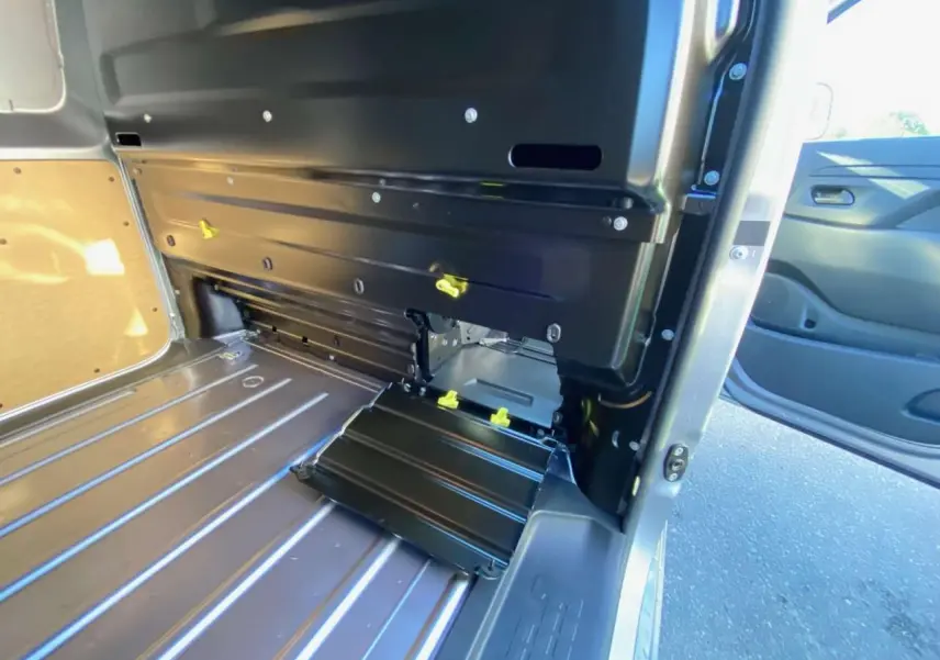 Vue intérieure de l'espace de chargement du Peugeot Expert Fourgon gris Artense, avec porte latérale ouverte et plancher métallique.