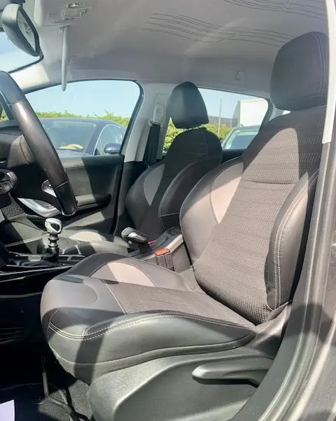 Intérieur avant droit du Peugeot 2008 gris 2015, sièges tissu et cuir, volant et levier de vitesse manuelle visibles.