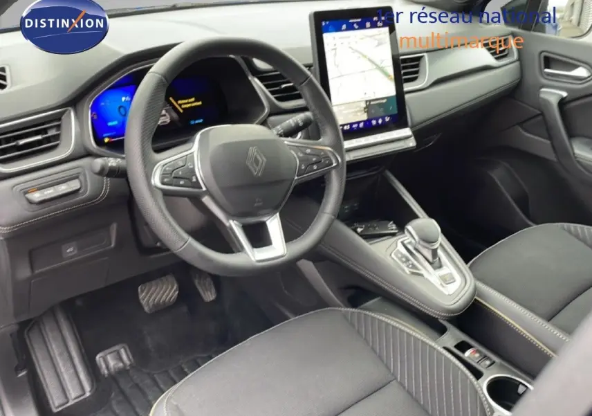 Vue intérieure côté conducteur de la Renault Symbioz 2025, tableau de bord noir avec écran tactile vertical et volant multifonction.