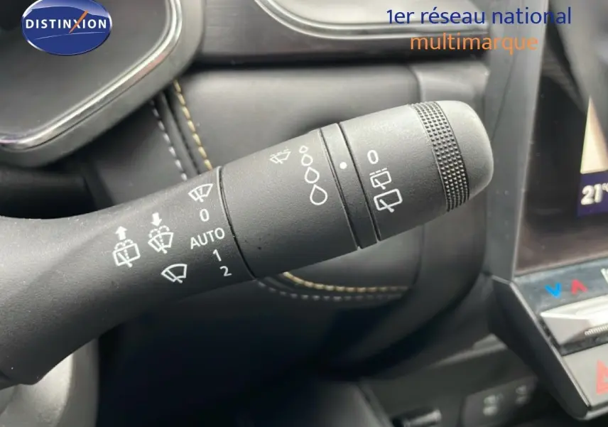 Gros plan sur la commande d’essuie-glace à gauche du volant dans l’habitacle noir du Renault Symbioz bleu Iron Metal.