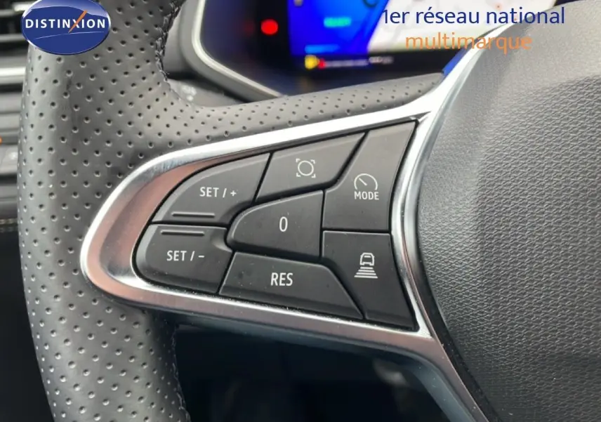 Gros plan sur les commandes de régulateur de vitesse au volant perforé d’un Renault Symbioz bleu Iron Metal.