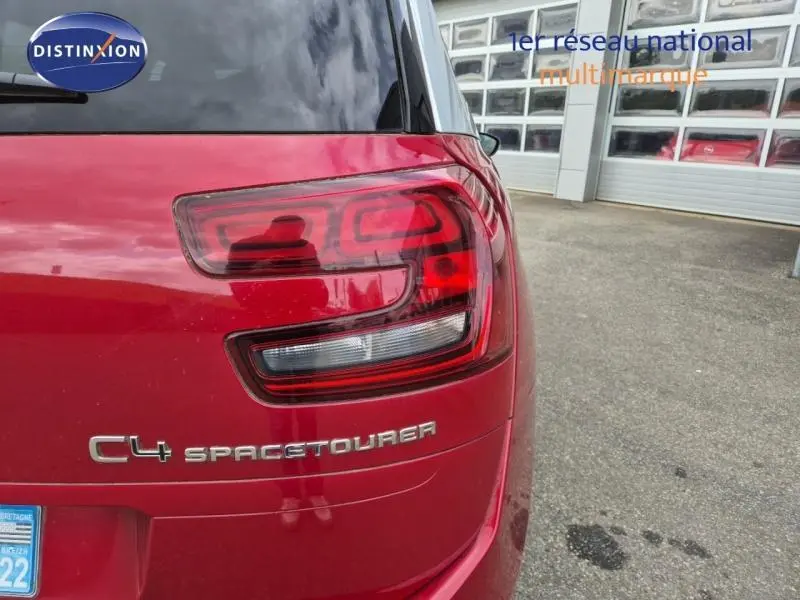 Gros plan sur le feu arrière gauche rouge rubi du Citroën Grand C4 Spacetourer avec logo et carrosserie visible.