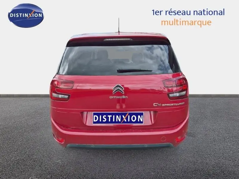 Vue arrière d'un Citroën Grand C4 Spacetourer rouge Rubi avec vitres arrière surteintées et logo distinctif.