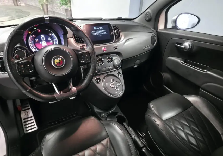 Intérieur noir cuir de l'Abarth 500 595C 2021 vu côté conducteur, avec volant sport et tableau de bord moderne.
