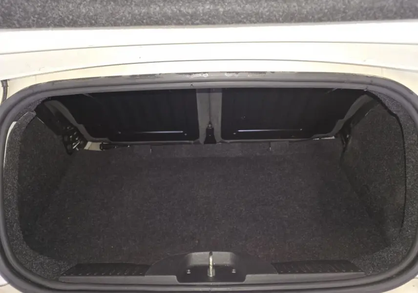 Coffre ouvert d'une Abarth 500 blanc Gara, montrant l'espace de rangement vide et la finition intérieure noire.