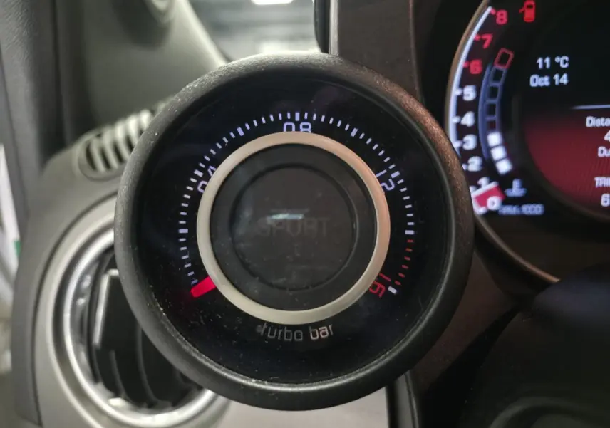 Gros plan sur le manomètre de pression turbo avec mode Sport, tableau de bord gris satiné de l'Abarth 595C blanc.