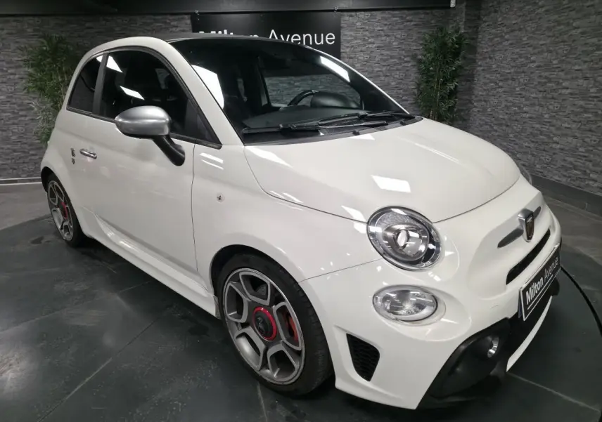 ABARTH 500 blanc en 3/4 avant droit, avec étriers de frein rouges et coques de rétroviseurs chrome satiné.