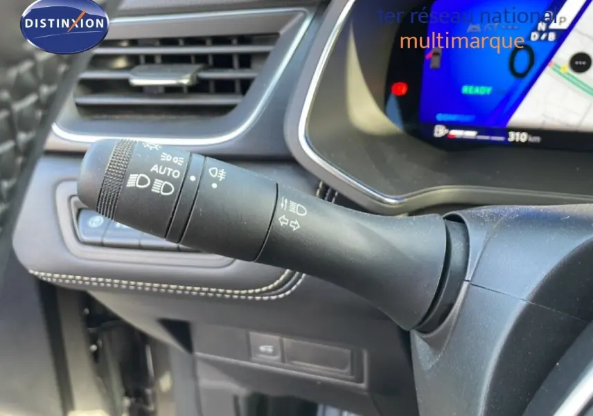 Gros plan sur la commande des feux et clignotants à gauche du volant dans l’habitacle gris noir du Renault Symbioz 2025.
