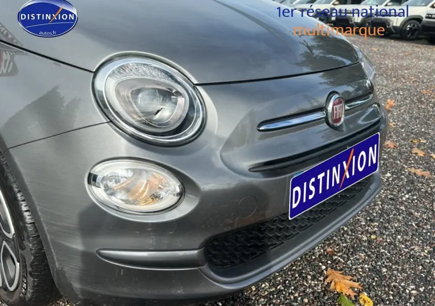 Vue 3/4 avant gauche d'une FIAT 500 gris métallisé avec phares ronds et calandre chromée.
