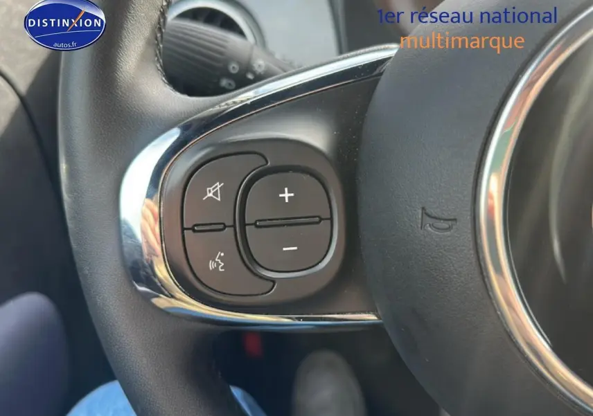 Gros plan sur les commandes audio au volant côté gauche d'une Fiat 500 gris 2022, avec finition chromée.
