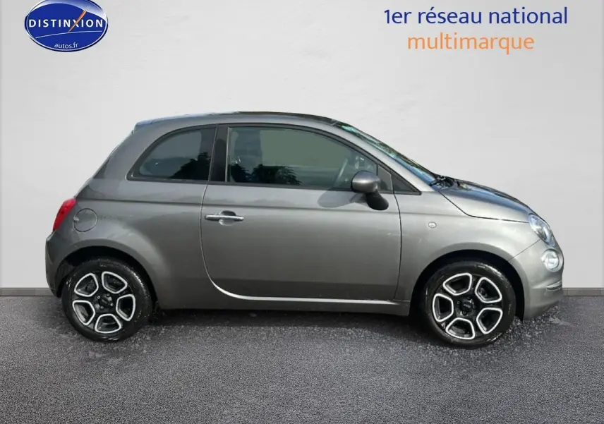 Profil droit d'une Fiat 500 gris métallisé de 2022 avec jantes alliage et poignées de porte chromées.