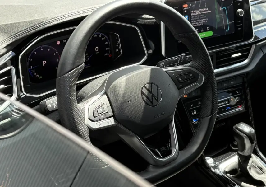 Vue rapprochée du volant cuir noir multifonction et du tableau de bord digital du Volkswagen T-Roc 2025.