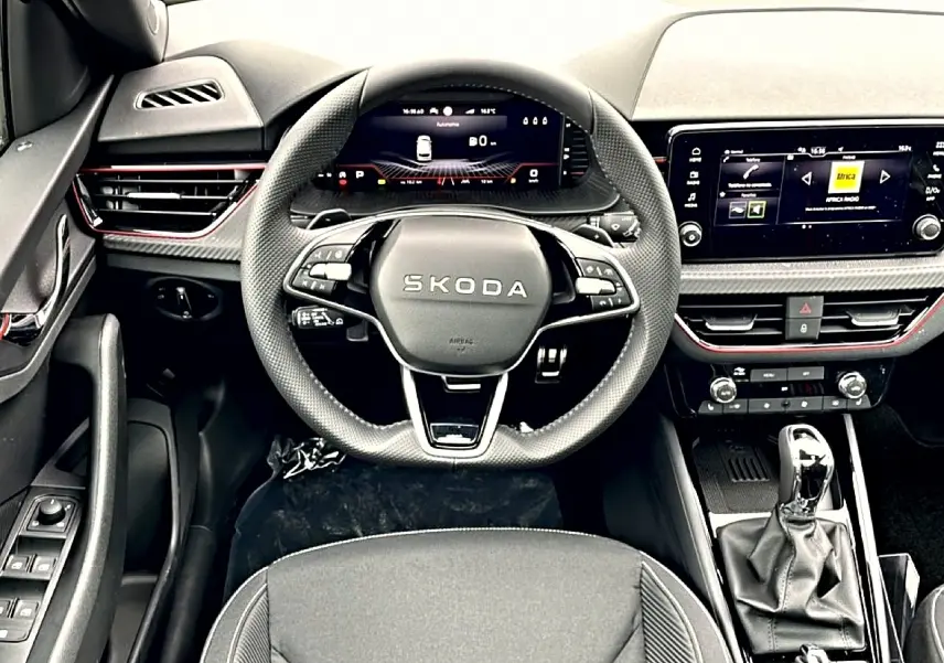 Vue intérieure frontale du poste de conduite noir du Skoda Kamiq 2026 avec volant multifonction et écran tactile central.