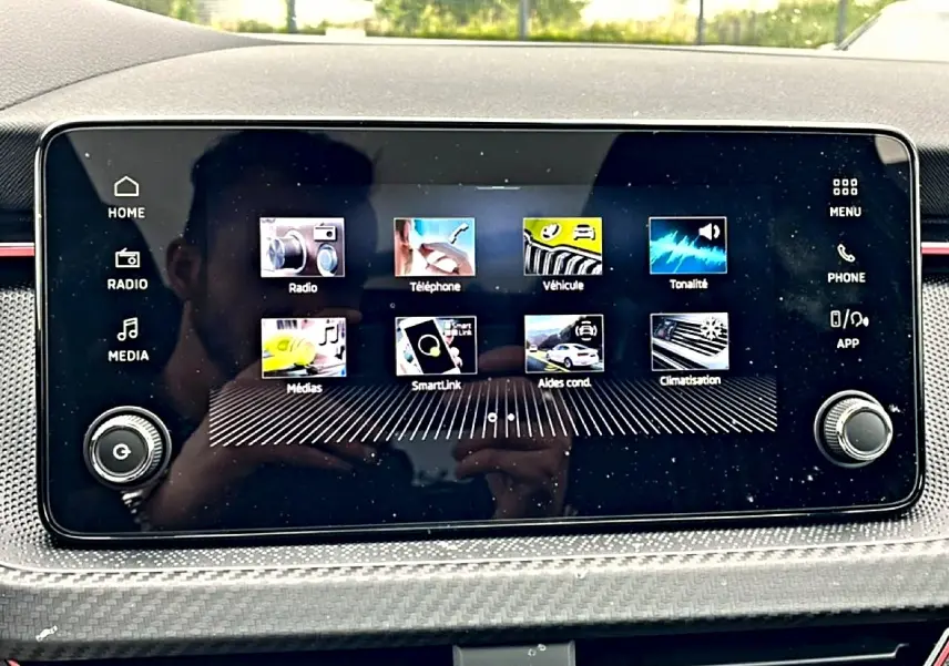 Écran tactile central du Skoda Kamiq 2026 affichant les menus radio, téléphone, véhicule et climatisation, avec cadre noir.