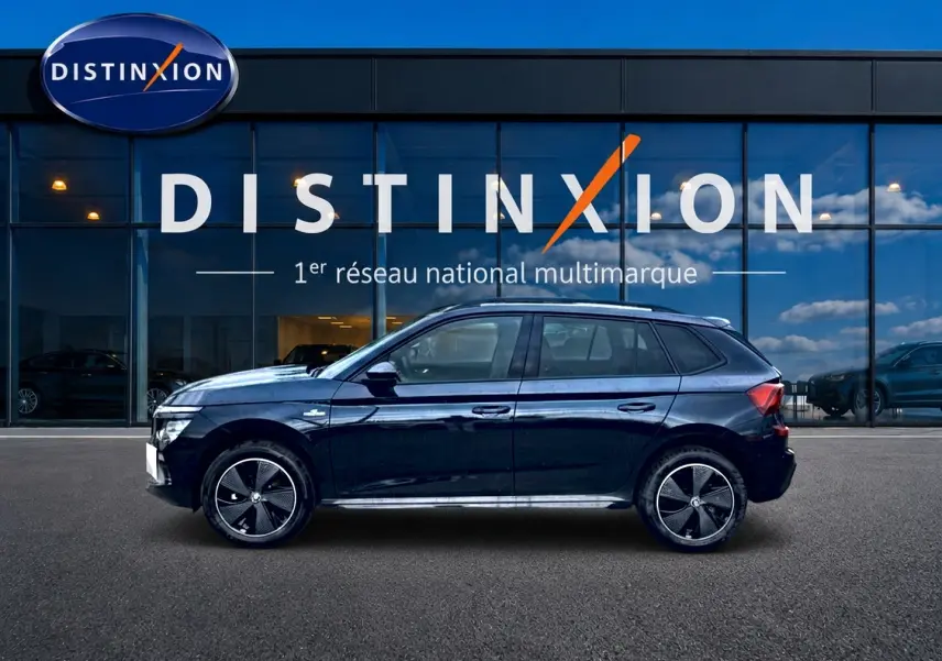 Vue latérale droite du Skoda Kamiq noir Monte Carlo 2026 avec jantes alu et toit panoramique, devant une vitrine Distinxion.