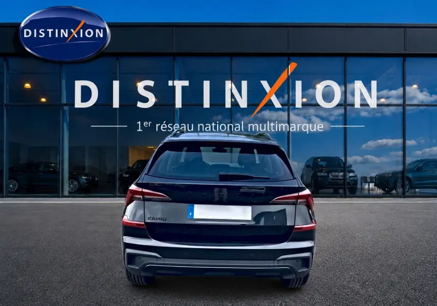 Vue arrière d'un Skoda Kamiq noir 2026 garé devant une vitrine avec logo Distinxion.