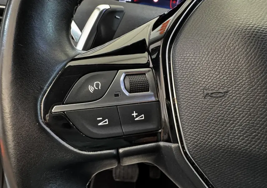Gros plan sur les commandes vocales et volume du volant cuir noir du Peugeot 5008 2022 BlueHDi.