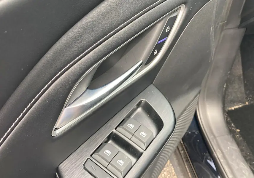 Détail de la porte avant gauche noire du MG ZS 1.5 hybrid 197 luxury avec commandes de vitres et verrouillage.