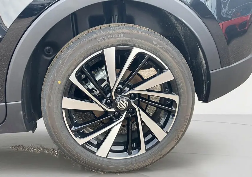 Gros plan sur la roue avant droite noire avec jante alu bicolore du MG Motor ZS 1.5 hybrid 197 luxury 2026.