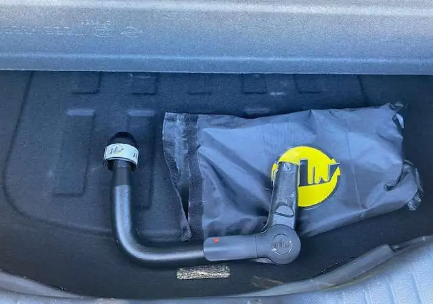 Gros plan sur l'attelage amovible noir dans le coffre du SsangYong Tivoli gris foncé 2021 version 160 e-XDi 2WD Pop.